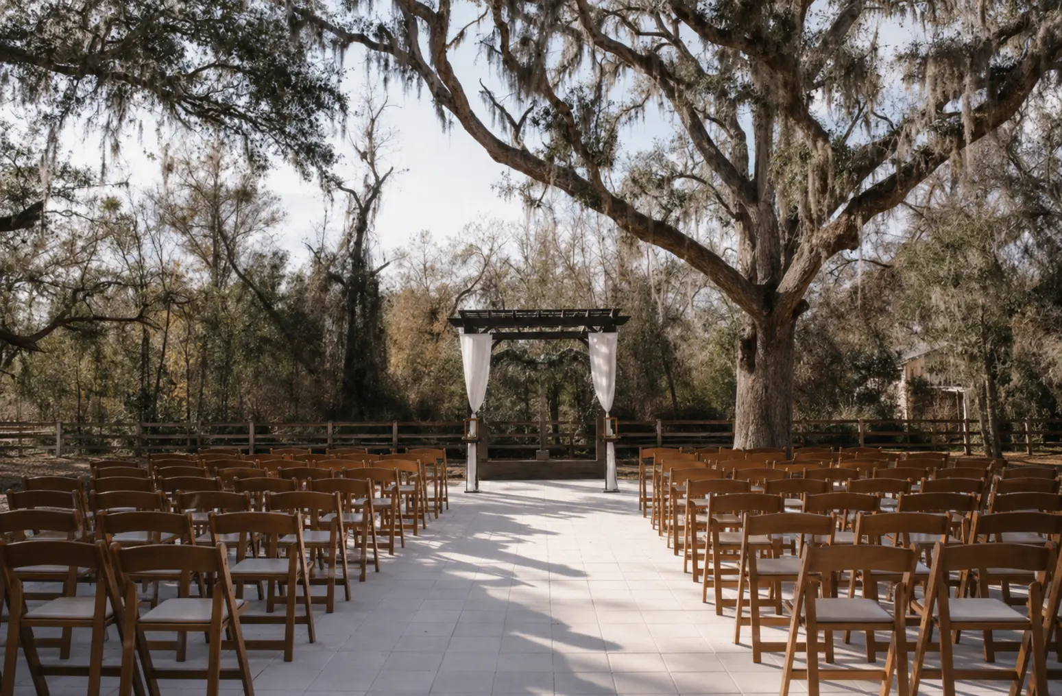 Ceremony aisle and arbor beneath the live oaks at The Madison Event Venue